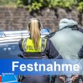 Polizistin und Polizist führen Mann in Handschellen zu einem Streifenwagen