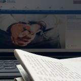 Bildschirm mit Zeitung und Kugelschreiber