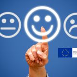Finger deutet auf Smileys- EU Flagge im rechten Bildrand