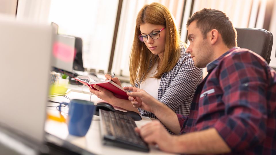 Eine Frau und ein Mann arbeiten gemeinsam an einem Schreibtisch